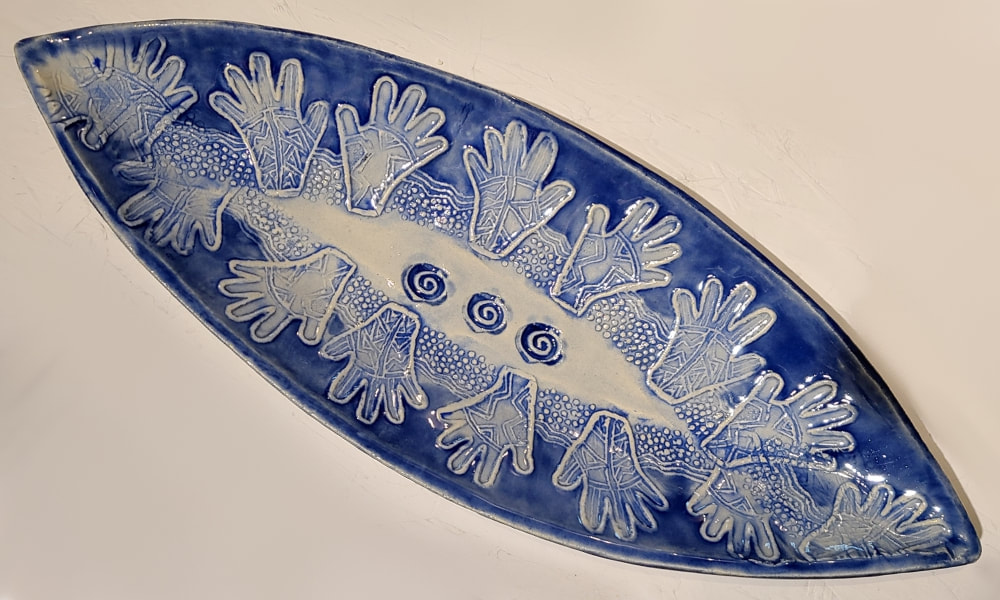 Blue Henna Hands Ceramic Boat, Clay has called to Linda Levy for over 50 years.  She has learned wheel throwing techniques, handbuilding, as well as glaze chemistry.  Her latest sculptural works are inspired by working with live models.  Linda's handbuilt plates and platters usually use her hand-created ceramic rollers to impart designs & textures.