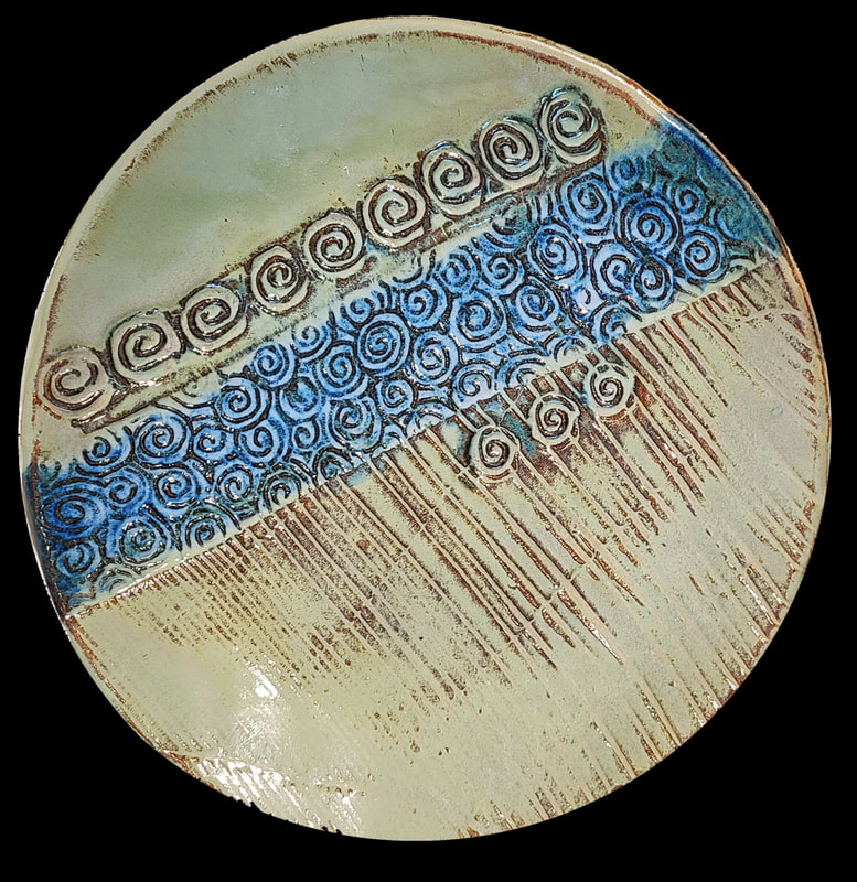 Ceramic plate -Spirals - on a Sandstone buff clay.  Fired to cone 6, oxidation. Clay has called to Linda Levy for over 50 years.  She has learned wheel throwing techniques, handbuilding, as well as glaze chemistry.  Her latest sculptural works are inspired by working with live models.  Linda's handbuilt plates and platters usually use her hand-created ceramic rollers to impart designs & textures.